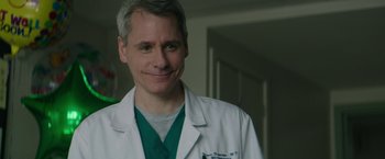 Movie still from “The Sea of Trees” (2015), directed by Gus Van Sant – A man in a white lab coat smiles for the camera; Close Up shot, Low angle