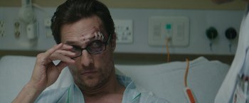 Movie still from “The Sea of Trees” (2015), directed by Gus Van Sant – A person wearing glasses; Close Up shot, Over the shoulder angle