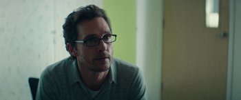 Movie still from “The Sea of Trees” (2015), directed by Gus Van Sant – A person wearing glasses; Close Up shot, Over the shoulder angle