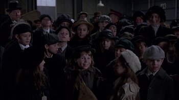 Movie still from “The Secret Garden” (1993), directed by Agnieszka Holland – A group of children in hats and coats standing in a room; Medium shot, High angle