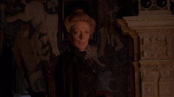 Movie still from “The Secret Garden” (1993), directed by Agnieszka Holland – An older woman wearing a black dress in front of a painting; Medium shot, Over the shoulder angle