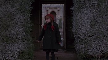 Movie still from “The Secret Garden” (1993), directed by Agnieszka Holland – A little girl wearing a red hat and coat; Medium shot, High angle