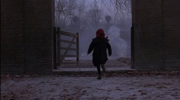 Movie still from “The Secret Garden” (1993), directed by Agnieszka Holland – A person walking through a gate on a snowy day; Wide shot, High angle