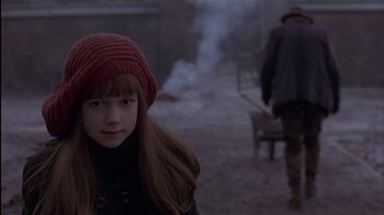 Movie still from “The Secret Garden” (1993), directed by Agnieszka Holland – A young girl wearing a red hat in the snow; Close Up shot, Over the shoulder angle