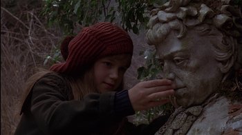 Movie still from “The Secret Garden” (1993), directed by Agnieszka Holland – A young girl touching the face of a statue; Close Up shot, Over the shoulder angle