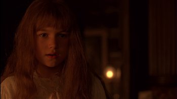 Movie still from “The Secret Garden” (1993), directed by Agnieszka Holland – A young girl is standing in a dimly - lit room; Close Up shot, Over the shoulder angle