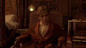 Movie still from “The Secret Garden” (1993), directed by Agnieszka Holland – A young boy sitting in a wicker chair wearing a robe; Close Up shot, High angle