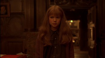 Movie still from “The Secret Garden” (1993), directed by Agnieszka Holland – A young girl with long red hair standing in a dark room; Close Up shot, High angle