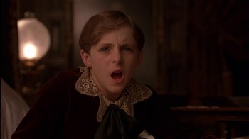 Movie still from “The Secret Garden” (1993), directed by Agnieszka Holland – A young boy wearing a brown shirt and a black tie; Close Up shot, Low angle
