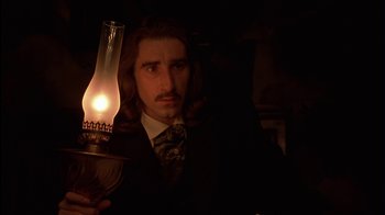 Movie still from “The Secret Garden” (1993), directed by Agnieszka Holland – A man in a suit holding an oil lamp in a dark room; Close Up shot, Low angle
