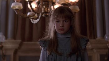 Movie still from “The Secret Garden” (1993), directed by Agnieszka Holland – A young girl in a dress standing in front of a chandelier; Close Up shot, Low angle