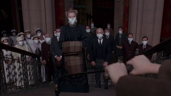 Movie still from “The Secret Garden” (1993), directed by Agnieszka Holland – A group of people wearing face masks in front of an audience; Medium shot, Low angle