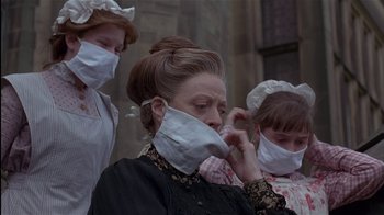 Movie still from “The Secret Garden” (1993), directed by Agnieszka Holland – A woman wearing a face mask while standing next to two other women; Close Up shot, Low angle