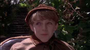 Movie still from “The Secret Garden” (1993), directed by Agnieszka Holland – A young boy wearing a brown hat and a brown coat; Close Up shot, High angle