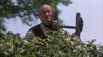 Movie still from “The Secret Garden” (1993), directed by Agnieszka Holland – An older man holding a wooden stick in front of a bush; Medium shot, Low angle