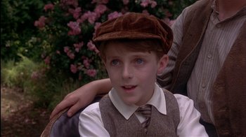 Movie still from “The Secret Garden” (1993), directed by Agnieszka Holland – A young boy wearing a brown hat and a tie; Close Up shot, Over the shoulder angle