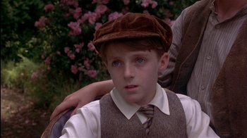 Movie still from “The Secret Garden” (1993), directed by Agnieszka Holland – A young boy wearing a brown hat and tie; Close Up shot, Over the shoulder angle