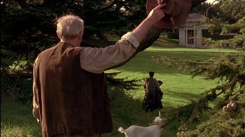Movie still from “The Secret Garden” (1993), directed by Agnieszka Holland – An older man holding a hat over his head while riding a horse; Medium shot, Over the shoulder angle