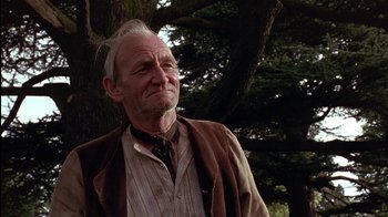 Movie still from “The Secret Garden” (1993), directed by Agnieszka Holland – An old man with a beard and a scarf standing in front of a tree; Close Up shot, Low angle