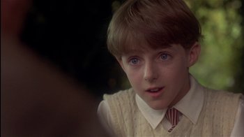 Movie still from “The Secret Garden” (1993), directed by Agnieszka Holland – A young boy wearing a sweater and a tie; Close Up shot, Over the shoulder angle