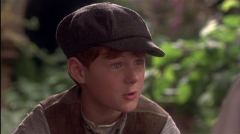 Movie still from “The Secret Garden” (1993), directed by Agnieszka Holland – A young boy wearing a hat and vest; Close Up shot, Low angle