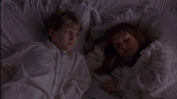 Movie still from “The Secret Garden” (1993), directed by Agnieszka Holland – Two children are sleeping in a bed with white sheets; Medium shot, High angle