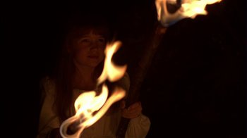 Movie still from “The Secret Garden” (1993), directed by Agnieszka Holland – A woman is holding a burning stick in the dark; Close Up shot, Low angle