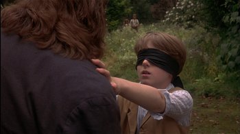 Movie still from “The Secret Garden” (1993), directed by Agnieszka Holland – A young boy is blindfolded by another boy; Close Up shot, Over the shoulder angle