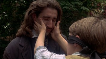 Movie still from “The Secret Garden” (1993), directed by Agnieszka Holland – A young boy blindfolds a young man with his hands over his eyes; Close Up shot, Over the shoulder angle