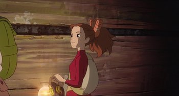 Movie still from “The Secret World of Arrietty” (2010), directed by Hiromasa Yonebayashi – A woman in a red shirt is holding a banana in her hand; Medium shot, Over the shoulder angle
