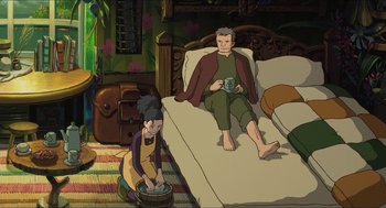 Movie still from “The Secret World of Arrietty” (2010), directed by Hiromasa Yonebayashi – An animated scene of a man and a woman sitting on a bed; Wide shot, High angle