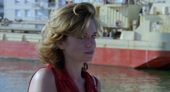 Movie still from “The Secret of the Grain” (2007), directed by Abdellatif Kechiche – A beautiful young woman with a red shirt and blonde curly hair; Close Up shot, Over the shoulder angle