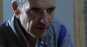 Movie still from “The Secret of the Grain” (2007), directed by Abdellatif Kechiche – An older man with grey hair and a mustache; Close Up shot, Low angle