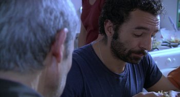Movie still from “The Secret of the Grain” (2007), directed by Abdellatif Kechiche – A man sitting in front of another man with a beard; Close Up shot, High angle