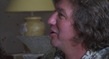 Movie still from “The Secret of the Grain” (2007), directed by Abdellatif Kechiche – An older woman with short curly grey hair; Close Up shot, Over the shoulder angle