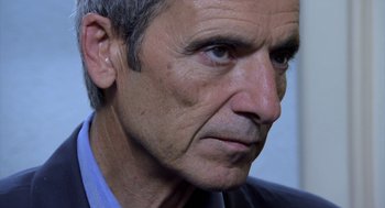 Movie still from “The Secret of the Grain” (2007), directed by Abdellatif Kechiche – An older man with grey hair and blue eyes; Close Up shot, Over the shoulder angle