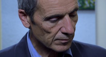 Movie still from “The Secret of the Grain” (2007), directed by Abdellatif Kechiche – An older man is looking down at his face; Close Up shot, Over the shoulder angle