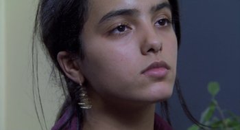Movie still from “The Secret of the Grain” (2007), directed by Abdellatif Kechiche – A person wearing a purple shirt; Close Up shot, Low angle