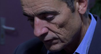 Movie still from “The Secret of the Grain” (2007), directed by Abdellatif Kechiche – A man's face as he looks down; Extreme Close Up shot, High angle