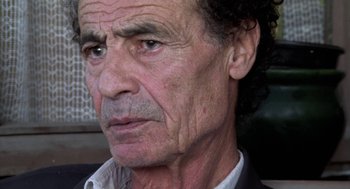 Movie still from “The Secret of the Grain” (2007), directed by Abdellatif Kechiche – An older man with a serious look on his face; Close Up shot, Low angle