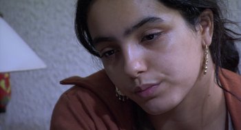 Movie still from “The Secret of the Grain” (2007), directed by Abdellatif Kechiche – A woman's face with her hand on her shoulder; Close Up shot, High angle