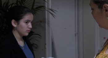 Movie still from “The Secret of the Grain” (2007), directed by Abdellatif Kechiche – A young girl standing next to a door; Medium shot, Over the shoulder angle