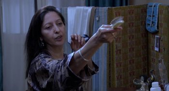 Movie still from “The Secret of the Grain” (2007), directed by Abdellatif Kechiche – A woman is holding something in her hands; Medium shot, High angle