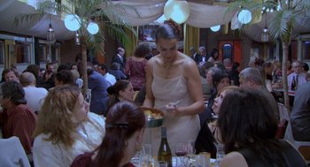 Movie still from “The Secret of the Grain” (2007), directed by Abdellatif Kechiche – A woman standing at a table with a plate of food; Medium shot, High angle