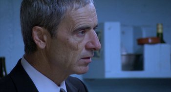 Movie still from “The Secret of the Grain” (2007), directed by Abdellatif Kechiche – An older man wearing a suit and tie looking to his left; Close Up shot, Over the shoulder angle