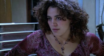 Movie still from “The Secret of the Grain” (2007), directed by Abdellatif Kechiche – A person with curly hair wearing a necklace; Close Up shot, High angle