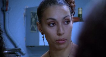 Movie still from “The Secret of the Grain” (2007), directed by Abdellatif Kechiche – A person wearing a necklace and earrings; Close Up shot, Over the shoulder angle