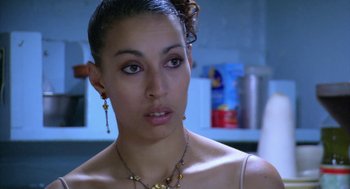 Movie still from “The Secret of the Grain” (2007), directed by Abdellatif Kechiche – A person wearing a necklace and earrings; Close Up shot, Over the shoulder angle