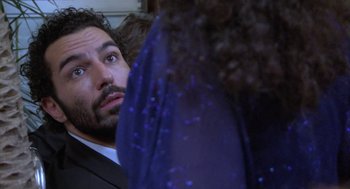Movie still from “The Secret of the Grain” (2007), directed by Abdellatif Kechiche – A person wearing a suit and a tie; Close Up shot, Over the shoulder angle