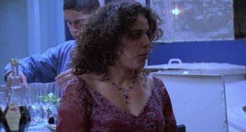 Movie still from “The Secret of the Grain” (2007), directed by Abdellatif Kechiche – A woman with curly hair is standing next to a man; Medium shot, Over the shoulder angle